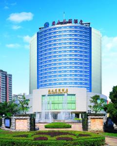 a large building with a fountain in front of it at Beijing Asia Pacific Garden Hotel in Tongzhou