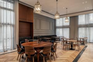 a dining room with tables and chairs and windows at Jo Shtibel Tel-Aviv in Tel Aviv