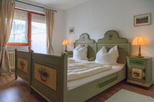 Schlafzimmer mit einem Bett mit weißer Bettwäsche und Kissen in der Unterkunft Haus Elisabeth in Marquartstein