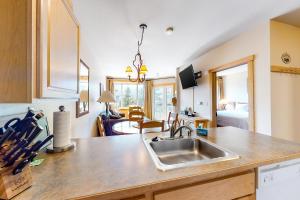 a kitchen with a sink and a living room at Juniper Springs 444 in Mammoth Lakes