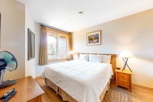 a bedroom with a bed and a desk and a window at Juniper Springs 444 in Mammoth Lakes