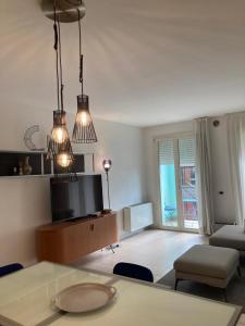 een woonkamer met een tafel en stoelen en een televisie bij Appartamento Golia in Vicenza