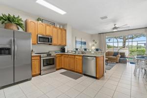 una cocina con armarios de madera y electrodomésticos de acero inoxidable en Magic Holiday House, en Orlando