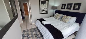 a bedroom with a bed with a blue head board at Knysna Sunrise @Malachite in Knysna