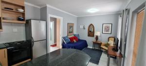 a kitchen with a refrigerator and a living room at Knysna Sunrise @Malachite in Knysna