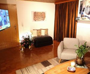 ein Wohnzimmer mit einem Bett und einem Stuhl in der Unterkunft Haus Edlinger in Hinterstoder