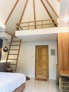 a bedroom with a loft bed and a staircase at Sirilagoona Home Resort in Nong Prue