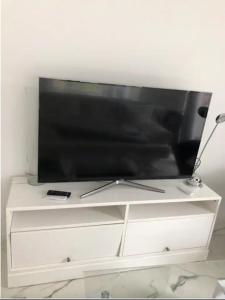 TV de pantalla plana en la parte superior de una cómoda blanca en Luxusvilla Neubau 1 en Oberasbach