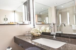 
a white sink sitting under a mirror in a bathroom at PLAZA Hotel Gelsenkirchen in Gelsenkirchen
