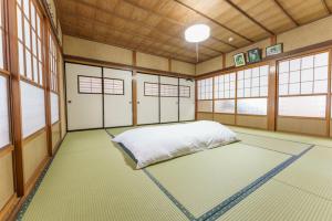 um quarto com uma cama num quarto com janelas em Bunzaemon em Itoigawa