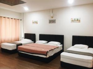 a bedroom with three beds in a room at Inapan Taman Herba in Kepala Batas