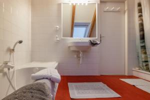 a bathroom with a sink and a tub and a mirror at Gailtal Appartements Nähe Skigebiet in Wertschach