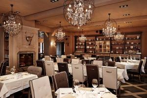 a restaurant with white tables and chairs and chandeliers at Villa Victoria-Loven Park Sofia in Sofia
