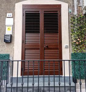 een houten deur aan de zijkant van een gebouw bij GE Suite in Catania