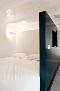 a bedroom with a white bed and a glass wall at Luna's Hideaway in Amsterdam