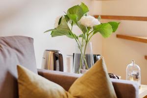 a vase of flowers sitting on top of a couch at homie hotel wiener botschaft in Veitshöchheim +21 photos