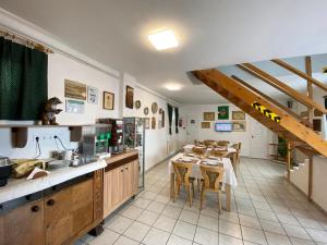 a kitchen with tables and chairs in a room at Hargita Panzio in Vecsés