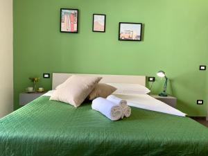 a green bedroom with a bed with towels on it at La Forgia in Grosseto