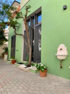 a green building with a tree in front of it at La Forgia in Grosseto