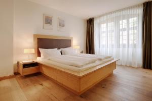 A bed or beds in a room at HOTEL WIENER BOTSCHAFT Veitshöchheim - by homekeepers