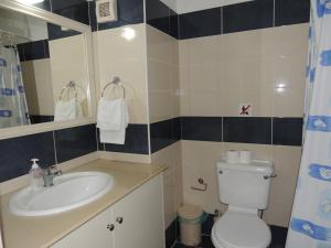 a bathroom with a toilet and a sink at West End Hotel in Peyia