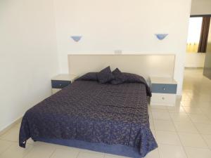 a bedroom with a bed and two night stands at West End Hotel in Peyia