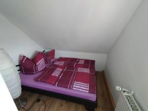 弗賴塔爾的住宿－FeWo Zur Alten Drechslerei，客房内的紫色床和红色枕头