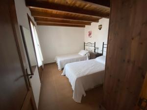 1 dormitorio con 2 camas y ventana en Pajero Las Cadenas, en Valverde