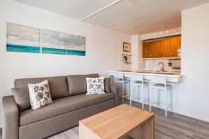 a living room with a couch and a kitchen at Roca Verde - Playa del Inglés in Playa del Ingles