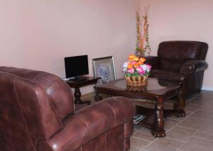 ein Wohnzimmer mit einem Sofa und einem Tisch mit Blumen darauf in der Unterkunft Belle View Apartment Villa- Lilac in Laborie