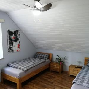 Schlafzimmer mit einem Bett und einem Deckenventilator in der Unterkunft Auerandzimmer in Nienhagen