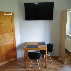 a table with two chairs and a television on a wall at Auerandzimmer in Nienhagen