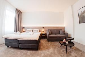 ein Hotelzimmer mit einem Bett und einem Sofa in der Unterkunft Hotel Reynaert Bv in Hulst