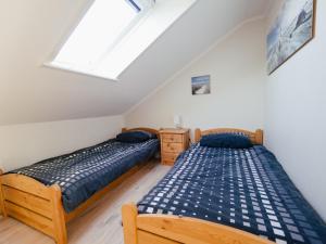 two twin beds in a bedroom with a skylight at Beachcomber House B in Friedrichskoog