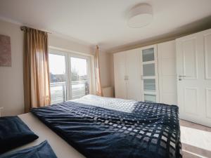 een slaapkamer met een bed en een groot raam bij Beachcomber House B in Friedrichskoog +3 foto's
