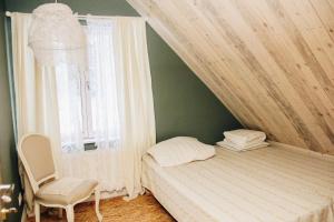a bedroom with a bed and a chair and a window at Loovälja Guesthouse in Limu