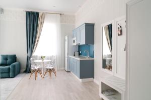 a kitchen with a table and a blue cabinet at Garmoniya Hotel in Lukhovitsy