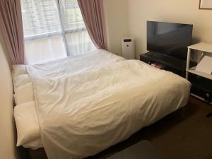 une chambre avec un lit et une télévision à écran plat dans l'établissement 駅南うちやまビル1, à Fukuoka
