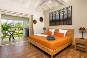 ein Schlafzimmer mit einem Bett mit orangefarbenen Kissen in der Unterkunft Les Galets Sxm in Saint Martin