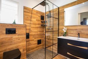 a bathroom with a glass shower and a sink at Les Galets Sxm in Saint Martin