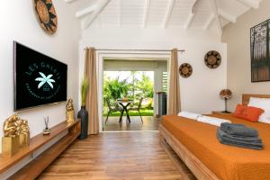 a bedroom with two beds and a dining room at Les Galets Sxm in Saint Martin
