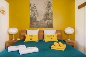 a bedroom with a bed with yellow walls and yellow pillows at Les Galets Sxm in Saint Martin