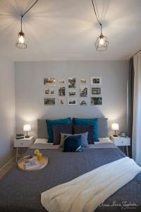 1 dormitorio con 1 cama grande con almohadas azules en Olszowa 14 by The River Apartment, en Varsovia