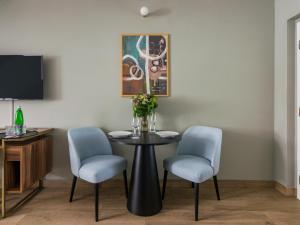 numa I Libusa Apartments في براغ: غرفة طعام مع طاولة وكرسيين