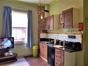 a kitchen with a tv in the corner of a room at The Alder Studio @ The Pheasant in Telford