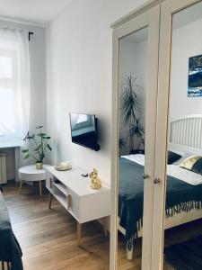 1 dormitorio con cama y espejo en Duo 2 Debniki Apartment en Cracovia