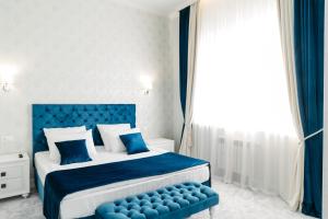 a blue and white bedroom with a bed and a blue bench at Garmoniya Hotel in Lukhovitsy