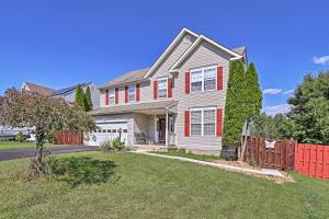 a house with a red fence in a yard at 32 Mi to DC Lower-Level Woodbridge Apt with Patio! in Woodbridge