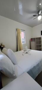 1 dormitorio con 1 cama blanca grande y ventilador de techo en Hotel La Castella, en San José