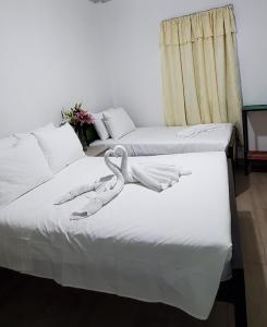 2 camas en una habitación con sábanas blancas en Hotel La Castella, en San José